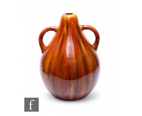 Burmantofts - An early 20th Century twin handled vase, of swollen tear drop form, streaked tonal brown and mustard glaze, imp
