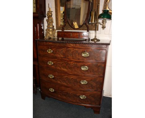A 19th century mahogany bow front chest of two short over three long drawers with brass oval drop handles, and egg and dart c