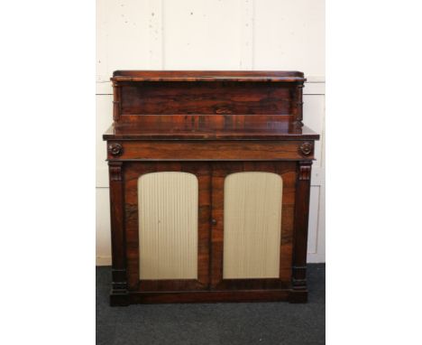 A Regency rosewood chiffonier with raised shelf back, frieze drawer, over two green folded silk panel doors, on plinth base, 