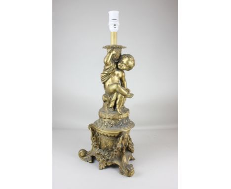 A gilt metal table lamp with cherub seated on garlanded plinth, on scrolled foliate base, 55.5cm
