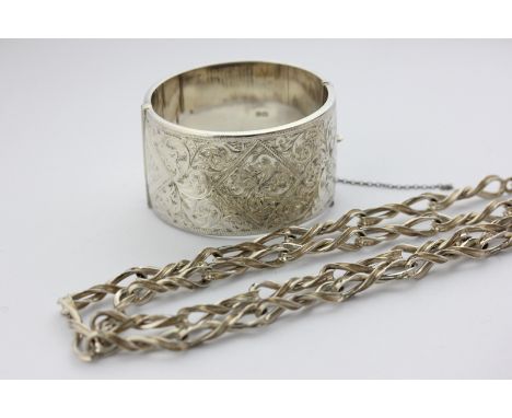 A silver bangle with leaf scroll decoration, and a silver ribbon twist necklace