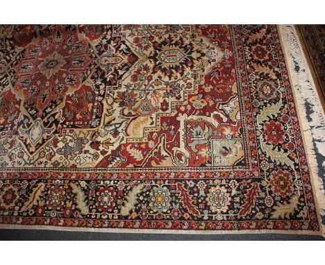 A Kadjar design woven wool carpet, red and cream ground, central floral motif and foliate pattern within multiple borders, Lo