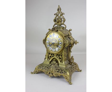 A French gilt metal mantel clock with pierced lion mask surmount, drum shaped dial, on scroll pierced support and base, (side