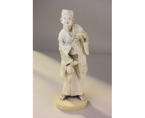 A 19th century Japanese ivory Okimono figure modelled as an old man holding a tea bowl and flask, mark to base, 21.5cm high