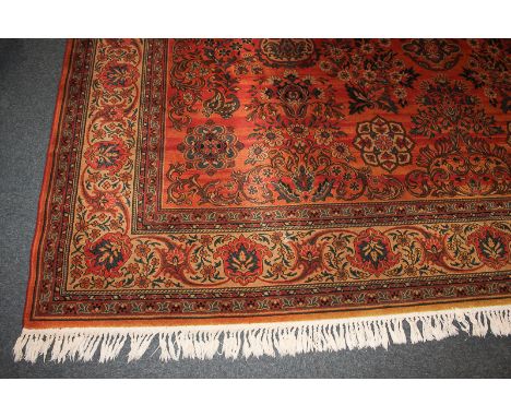 A Massoul design woven wool carpet, red and orange ground, with multi-guard border and repeat floral pattern in red, blue, br