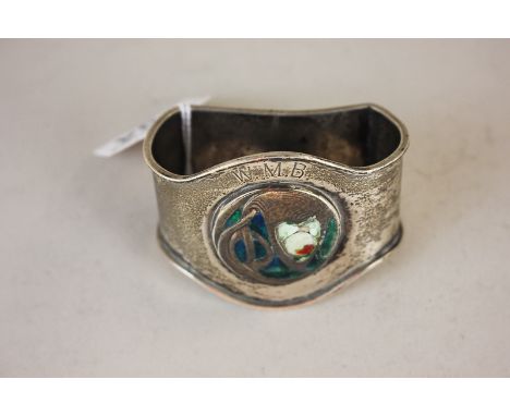 A Liberty style silver napkin ring with blue enamel roundel, engraved initials, maker William Hair Haseler, Birmingham 1905