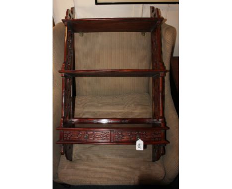 A 20th century mahogany three-tier wall shelf, the lower shelf with two small blind fret drawers, pierced lattice supports