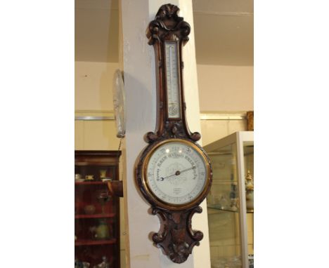 A Victorian carved oak banjo wall barometer and thermometer, with 8 inch dial marked J Hicks, London, 85cm