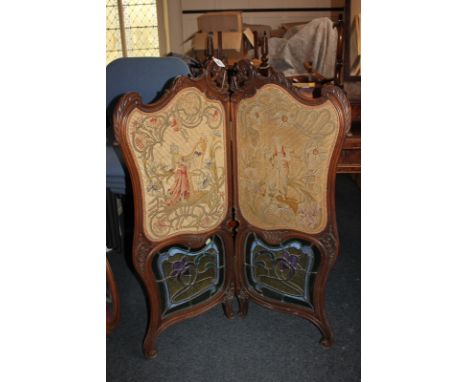 A French walnut two-section room screen with tapestry panels of figures above lead glazed panels within carved scroll border 