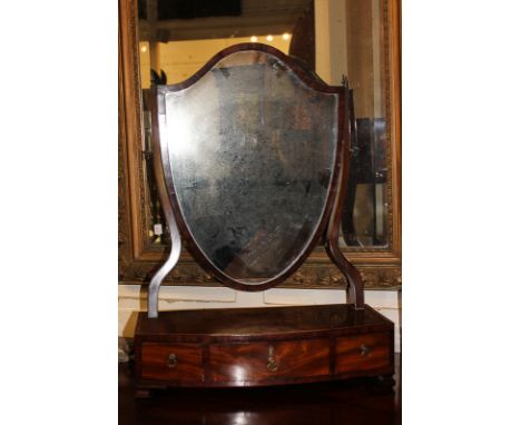 A George III mahogany shield shaped dressing table mirror on bow front box base with three drawers, on bracket feet (a/f), 50