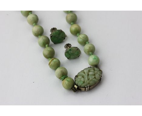 A jade bead necklace strung on a silver and jade clasp, and a pair of jade earrings
