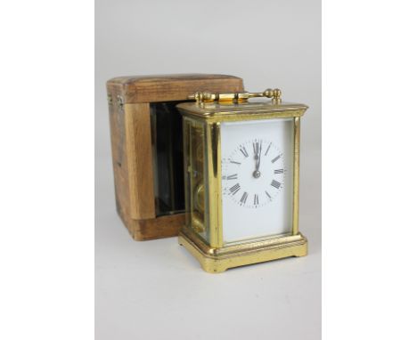 A French brass carriage clock, white enamel dial with Roman numerals, glazed side panels and back, with movement striking on 