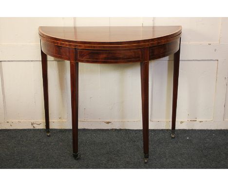 A Sheraton style inlaid mahogany demi-lune card table with fold-over top and green baize, satinwood banding, on square tapere