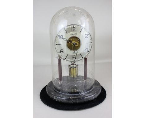 A Crescent eight day clock with circular silvered dial and gilt metal movement, on two pillar support, under etched glass dom