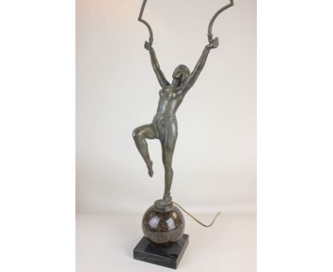 An Art Deco bronzed metal figure table lamp of a semi-nude lady dancer, arms held aloft, standing on marble globe and square 