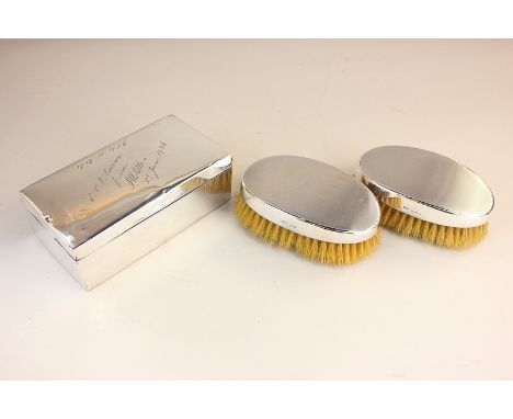 A pair of silver backed gentleman's dressing table brushes with engine turned decoration, and a rectangular cigarette box wit