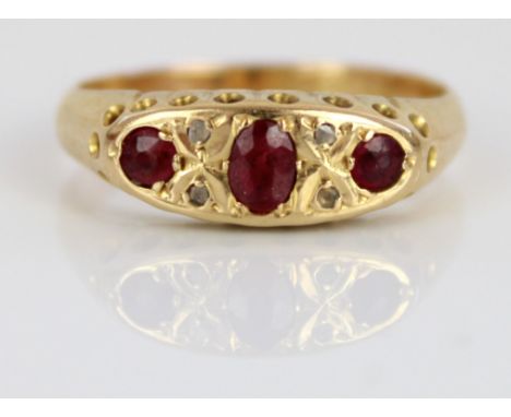 18ct yellow ruby and diamond ring, the three rubies and four diamonds in ornate rub-over setting, on plain shank, stamped 18c