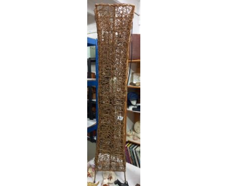 An ornate wicker floor standing lamp