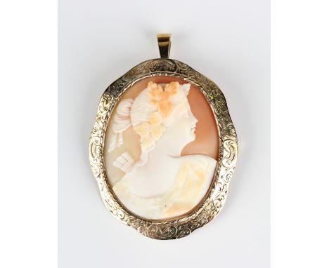 A gold mounted oval shell cameo pendant brooch, carved as a portrait of a lady, the mount with scroll engraved decoration, un