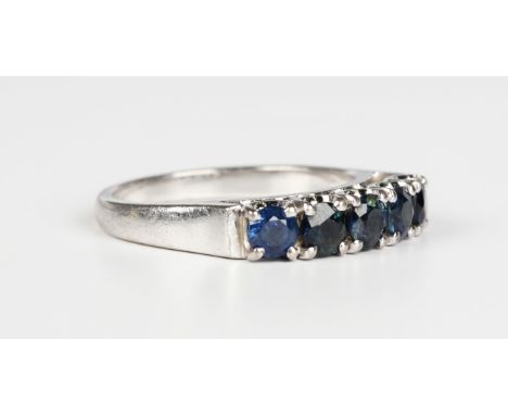 A white gold and sapphire ring, claw set with a row of five circular cut sapphires, detailed '18K, weight 4.2g, ring size app