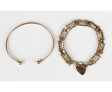 A 9ct gold decorated bar and oval link gate bracelet, length 18cm, on a 9ct gold heart shaped padlock clasp, and a 9ct gold t