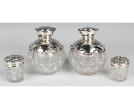 A pair of Edwardian silver mounted cut glass scent bottles and stoppers, each globular body with hinged lid, engraved with le