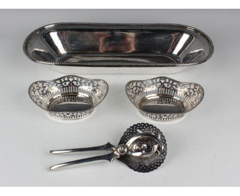 A pair of Elizabeth II silver oval sweetmeat baskets, each with pierced scroll sides beneath a beaded wavy rim, import mark L