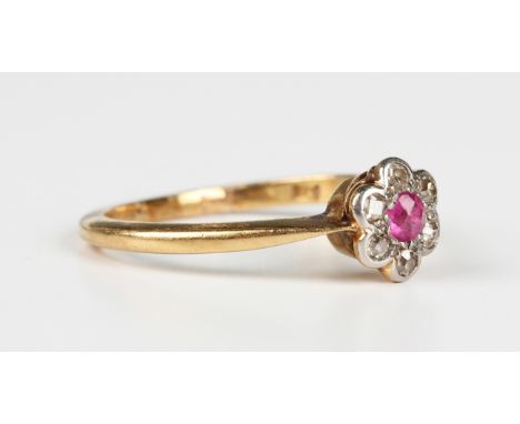 A gold, ruby and diamond seven stone cluster ring, mounted with a cushion cut ruby within a surround of six diamonds, detaile