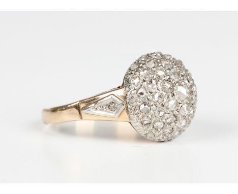 A diamond bombé style ring, mounted with rose cut diamonds between diamond set single stone shoulders and pierced sides, ring