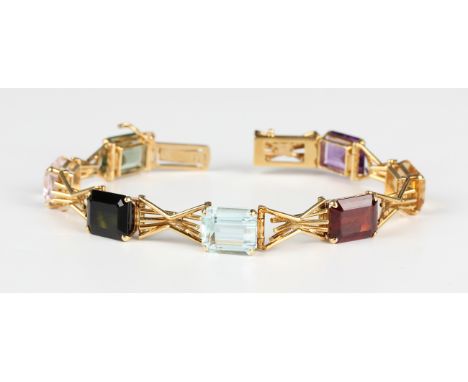 A gold and varicoloured gemstone bracelet, claw set with a row of seven cut cornered rectangular step cut varicoloured gemsto