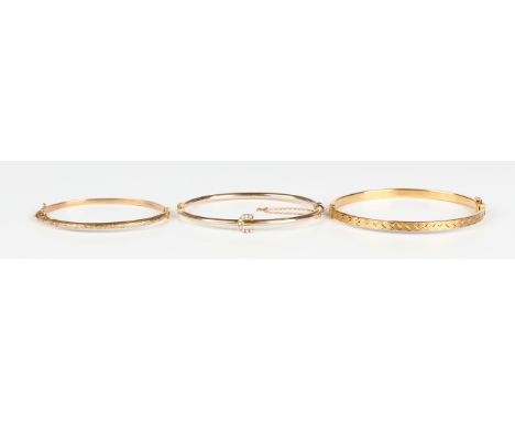 A gold and seed pearl oval hinged bangle with a horseshoe shaped motif, detailed '9ct', on a snap clasp, inside width 5.5cm, 
