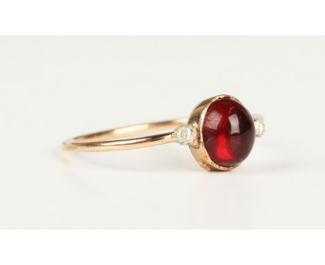 A gold, garnet and rose cut diamond ring, collet set with the oval cabochon garnet between two rose cut diamonds, with a hing