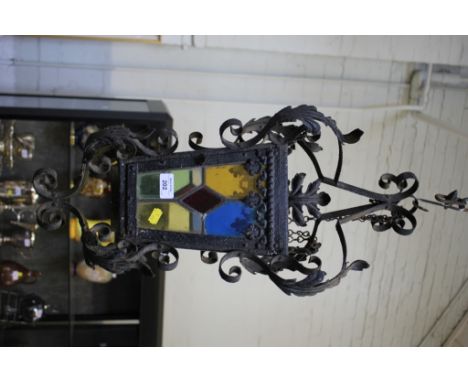 A wrought iron pedant light, with foliate scrolls and stained glass panels, 66cm high