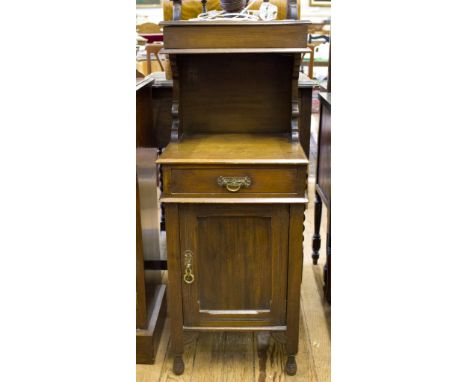 An Edwardian walnut bedside cabinet, with turned light fitting and gallery over a hinged box over a frieze drawer and cupboar