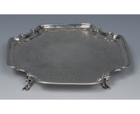 A George II Provincial silver shaped incurved square salver, the field flat chased with a band of flowers, scrolling foliage 