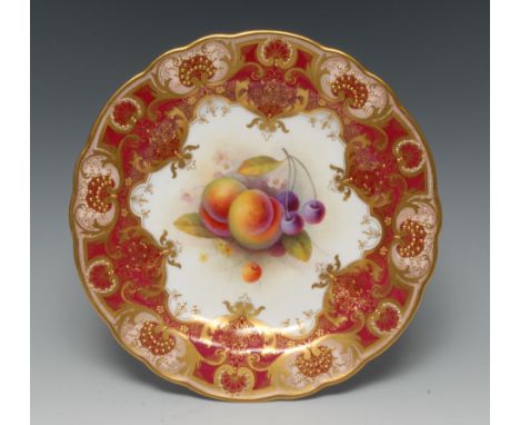 A Royal Worcester shaped circular plate, painted by Albert Shuck, signed, with ripe pears and blueberries, within fancy gilt 