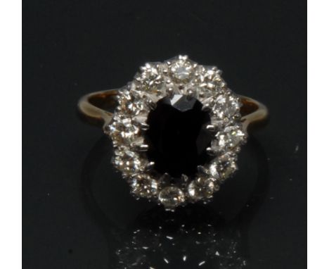 A diamond and sapphire cluster ring, central large oval dark blue sapphire measuring approx 9.6mm x 7.5mm x 4.5mm, estimated 
