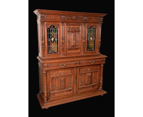 A 19th century Flemish oak side cabinet, central door flanked by a pair of stained and leaded glass doors, projecting base wi