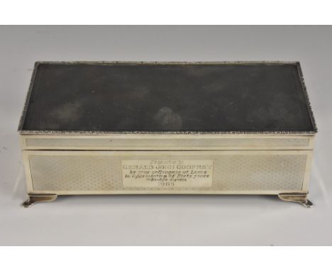 An Elizabeth II silver rectangular cigarette box, engine turned overall, hinged cover with leafy scroll border, bracket feet,