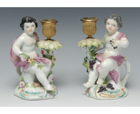A pair of Derby Patch Mark figural candlesticks, Allegorical of the Seasons, Spring and Autumn, seated scantily draped holdin