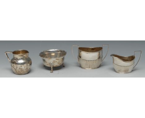 A Victorian silver half-fluted oval cream jug, angular scroll handle, 10.5cm long, Sheffield 1893; a sugar basket, similar, S