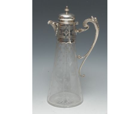 A Victorian E.P.N.S mounted clear glass trumpet shaped claret jug, hinged cover with knop finial, mask-capped divided scroll 