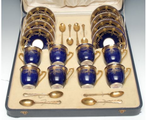 A set of eight Royal Worcester demi-tasse cups and saucers, decorated with flower heads and gilt swags on a cobalt blue groun