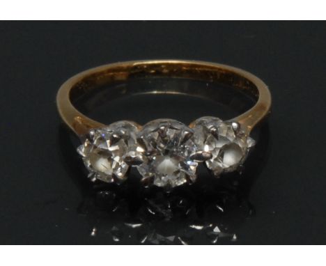 An early 20th century diamond trilogy ring, linear set with three irregular round old cut diamonds, total estimated diamond w
