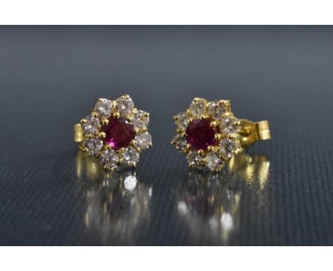 A pair of ruby and diamond floral cluster earrings, each with a central red ruby approx 0.33ct, surrounded by a band of eight