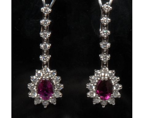 A pair of ruby and diamond drop earrings,  each with a central tear drop pinky red ruby, approx 0.50ct, surrounded by a band 