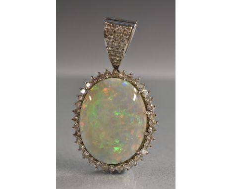 A large diamond and opal pendant, central oval opal cabochon, approx 23mm x 18mm x 7mm, flashing mixed colour play inc, red, 