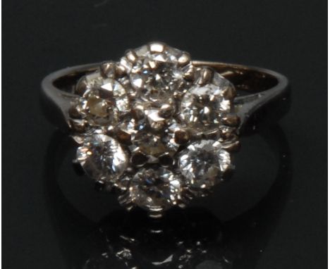 A diamond flower cluster ring, central raised round brilliant cut diamond approx 0.25ct, surrounded by a band of six conformi