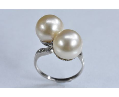A cultured pearl and diamond cross over ring, two large creamy white cultured pearls, each approx 10mm diameter, twist set ab
