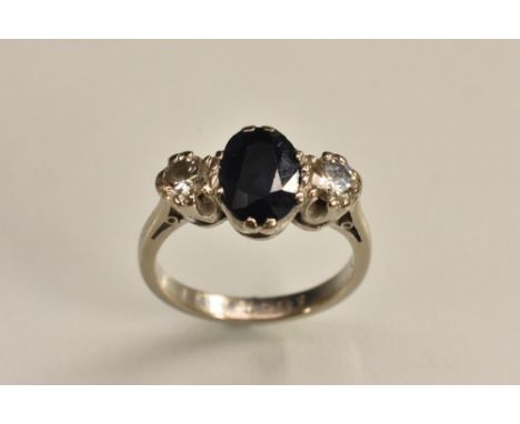 A diamond and sapphire trilogy ring, central oval banded deep blue sapphire, measuring approx 9mm x 6mm x 3mm, estimated ston